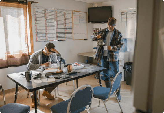 a person standing next to a person sitting at a table